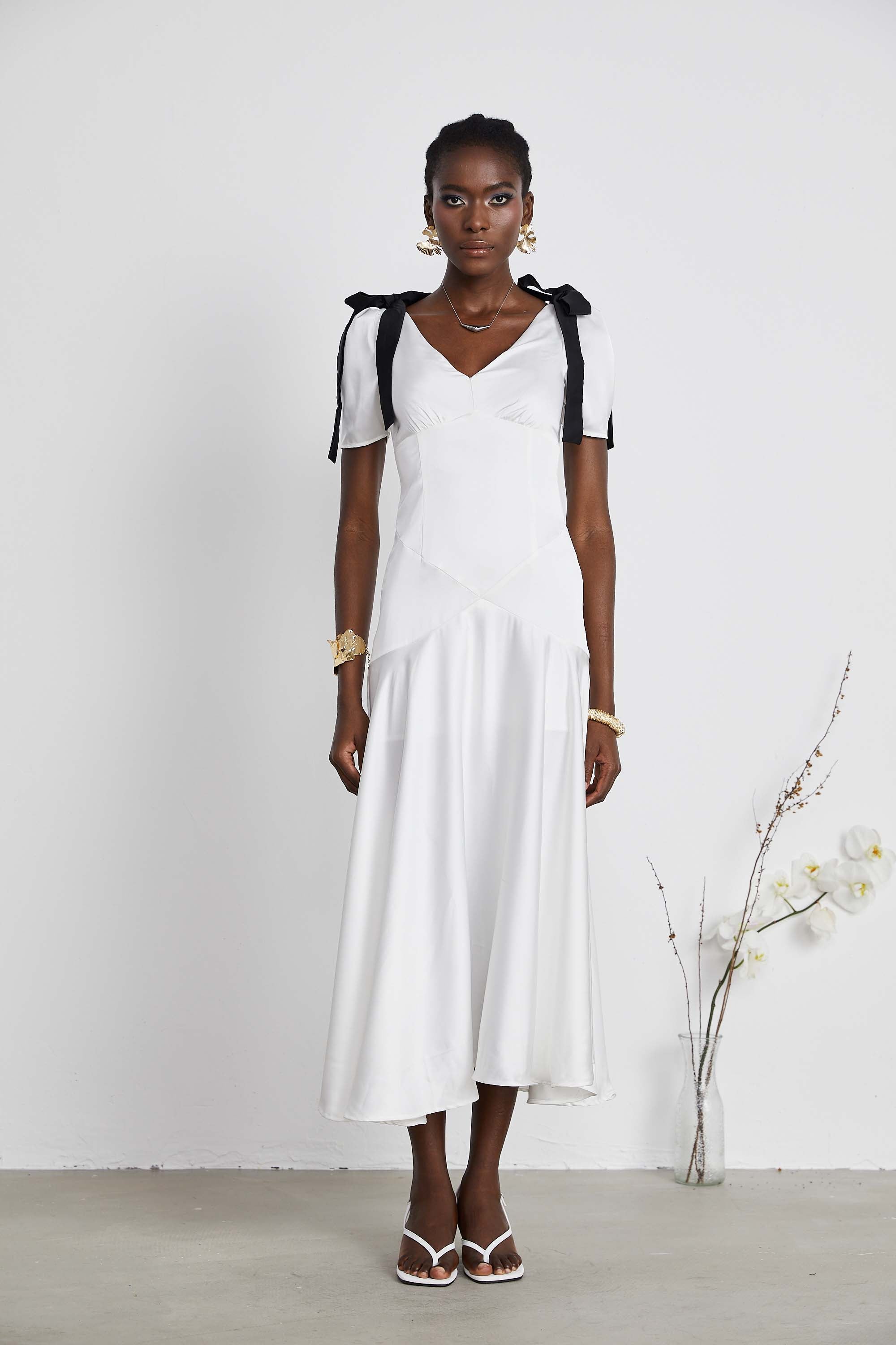 White satin V-neck midi dress with black bow shoulder straps