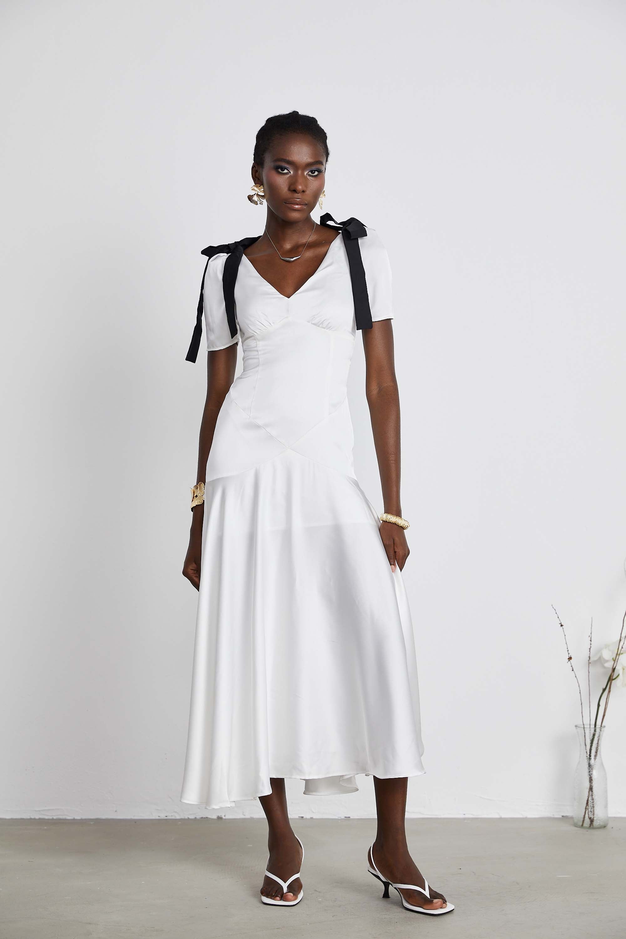 White satin V-neck midi dress with black bow shoulder straps