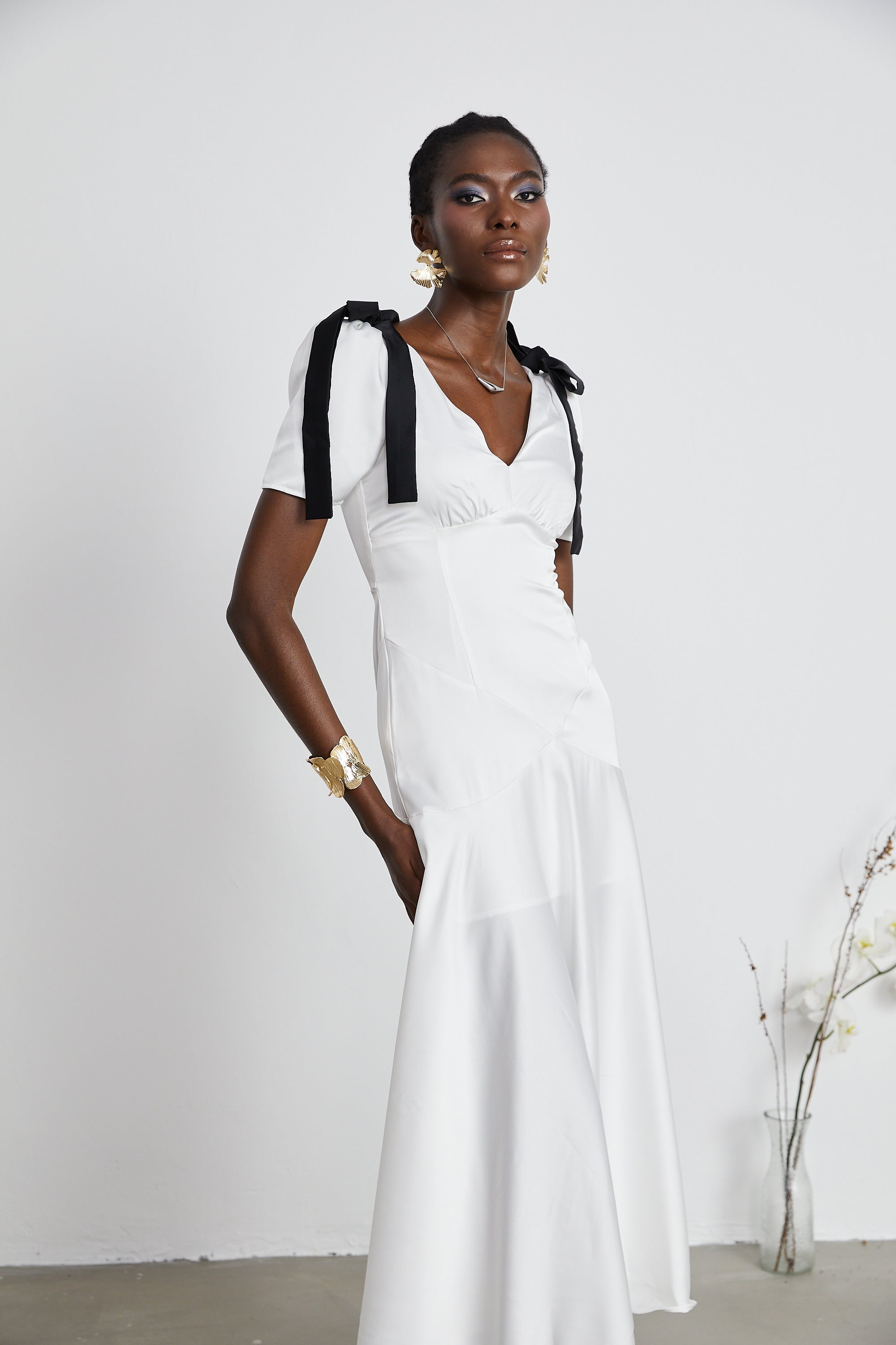 White satin V-neck midi dress with black bow shoulder straps