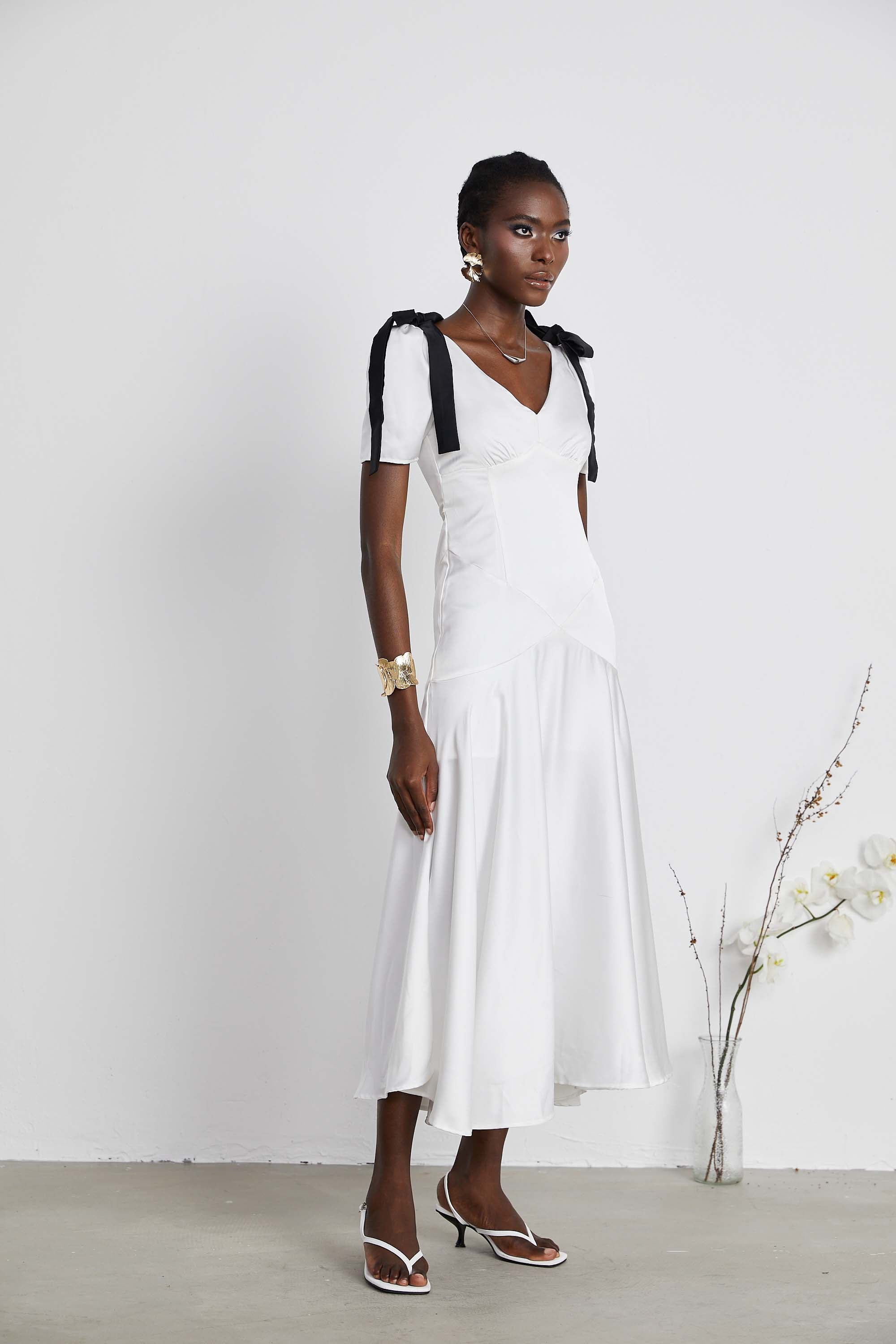 White satin V-neck midi dress with black bow shoulder straps